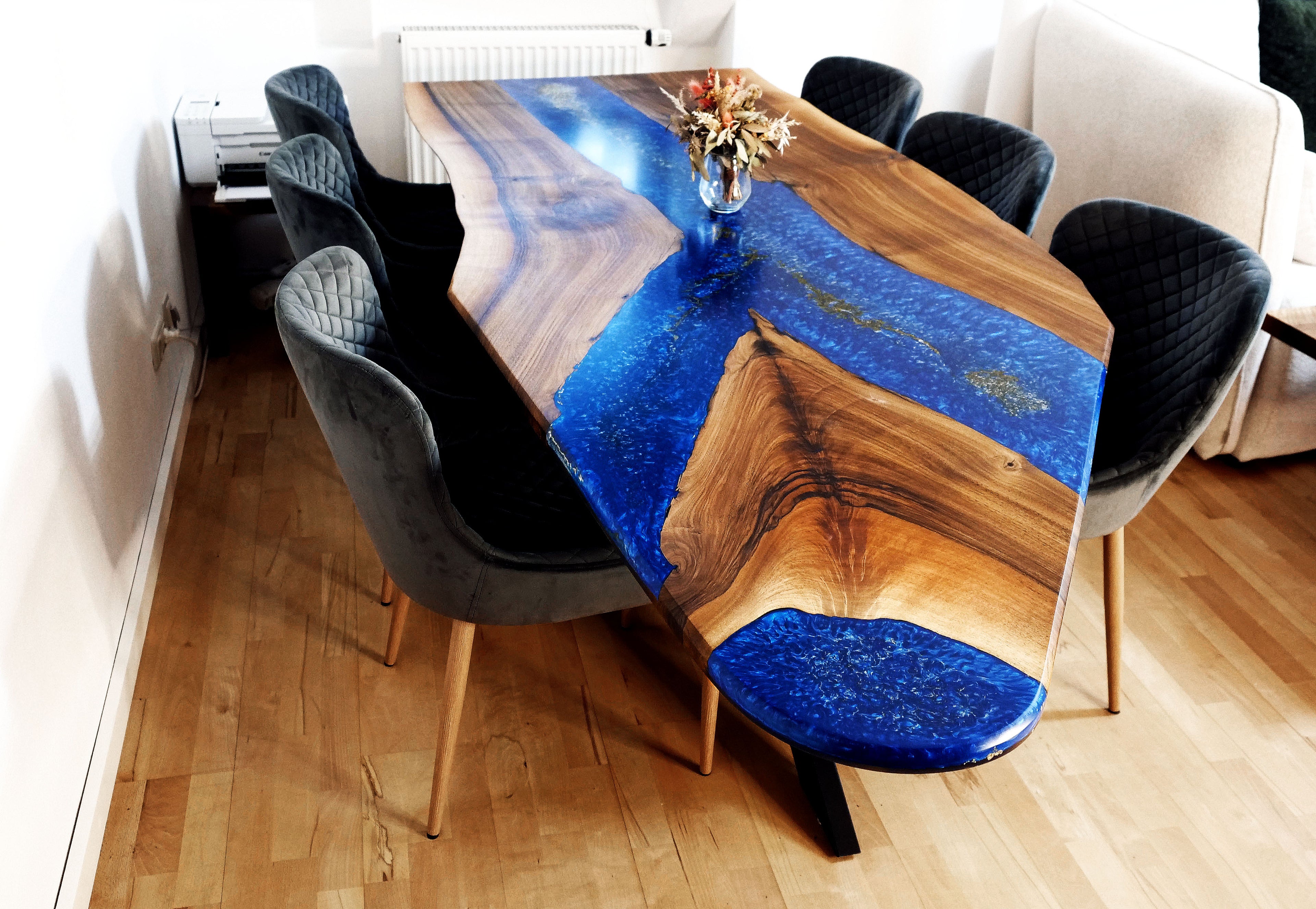 Luxus-Esstisch Blue Ember mit strukturierter Oberfläche und goldschimmerndem Harz – schräg von der gegenüberliegenden Seite aufgenommen. Ausdrucksstarke Handwerkskunst aus Massivholz.
