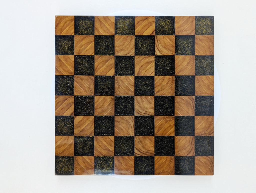 Vogelperspektive auf das Golden Gambit Schachbrett – quadratische Spielfläche aus Edelholz und Epoxidharz mit goldenen Akzenten. Hochwertige Handwerkskunst im FIDE-Format.