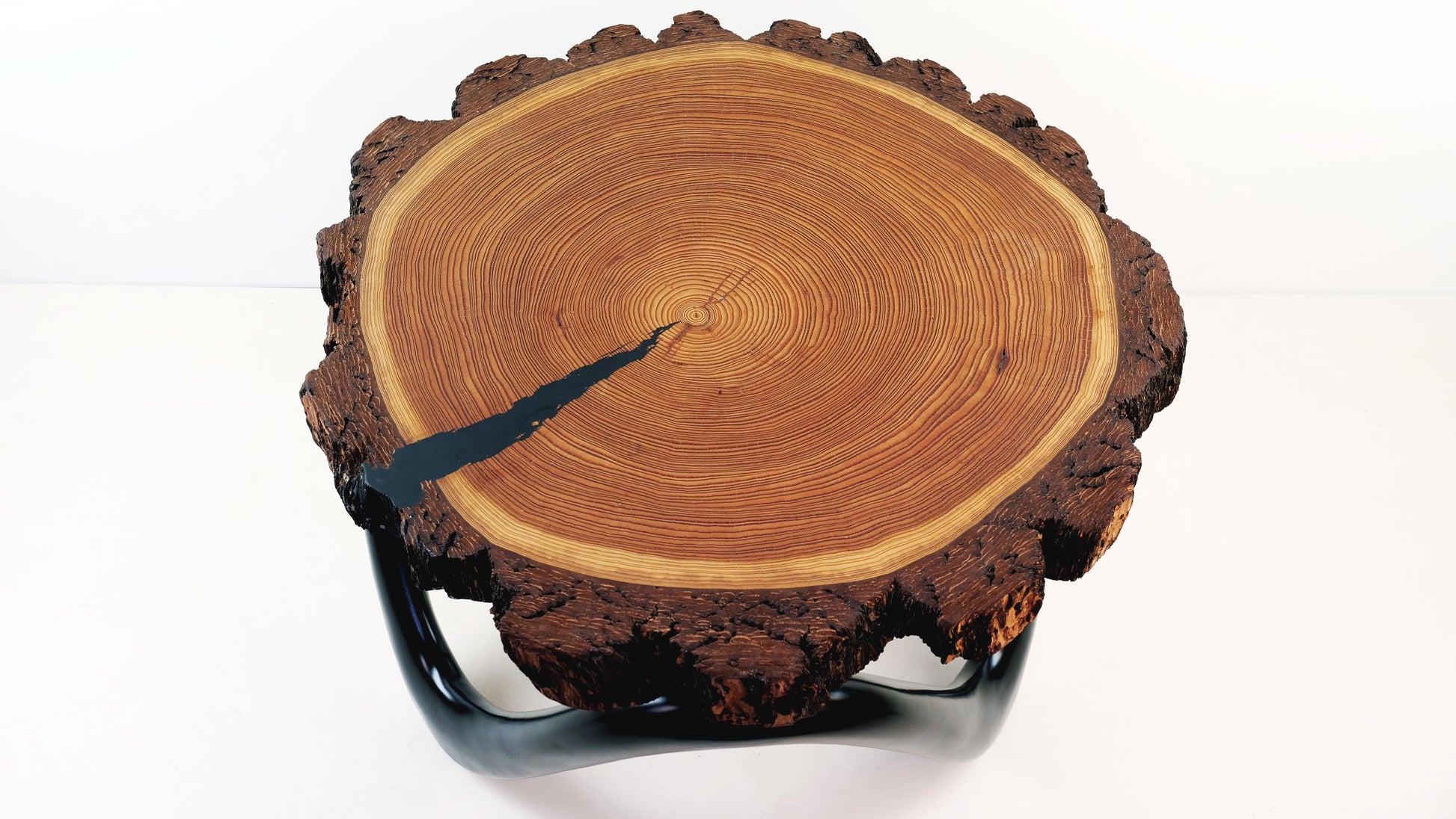 Draufsicht auf die Tischplatte des Nordic Wave Couchtischs aus Douglasie mit dunklem Epoxidharz – zeigt die natürliche Maserung und die handgefertigte Oberfläche eines hochwertigen Designprodukts.