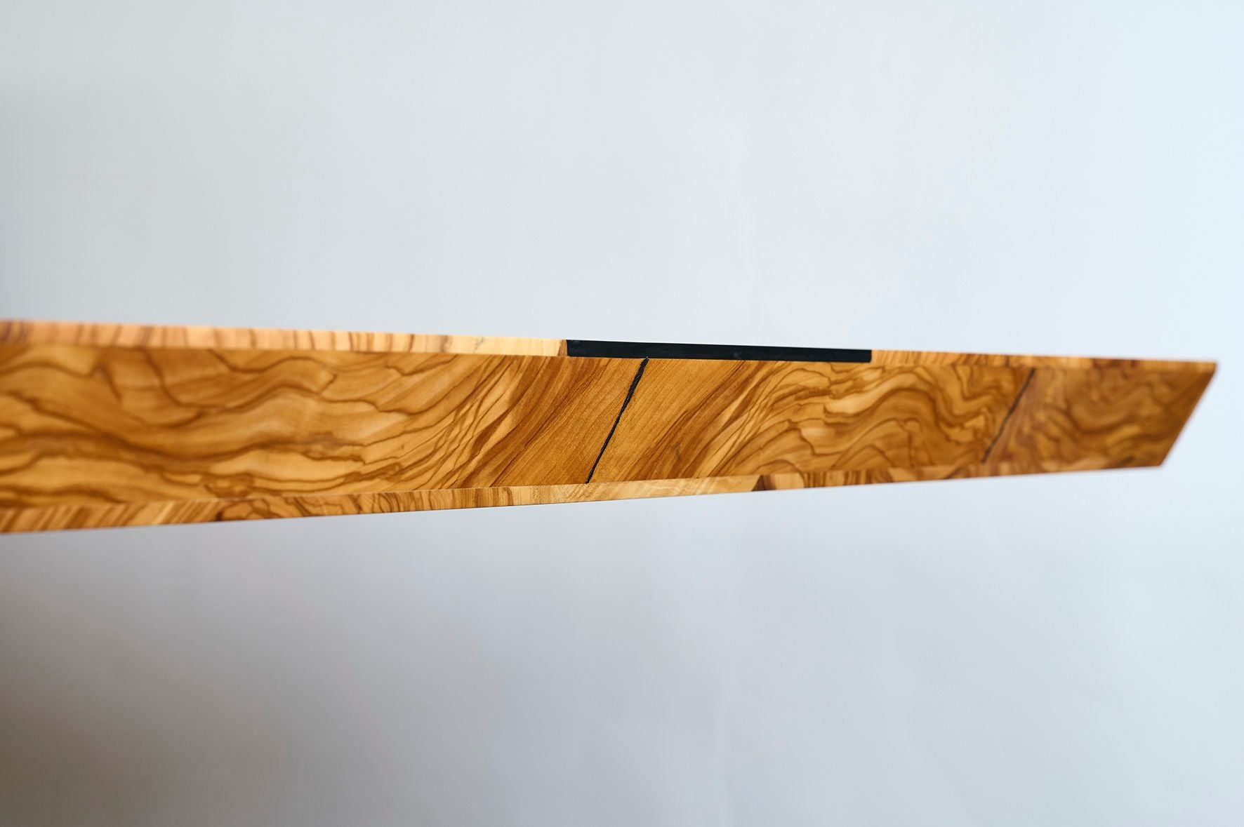 Terra Vero Schreibtisch mit charaktervoller Olivenholz-Maserung in Nahaufnahme – zeigt die natürliche Struktur und Tiefe des Massivholzes, ein einzigartiges Designprodukt in meisterlicher Handwerkskunst by Steigerwood.