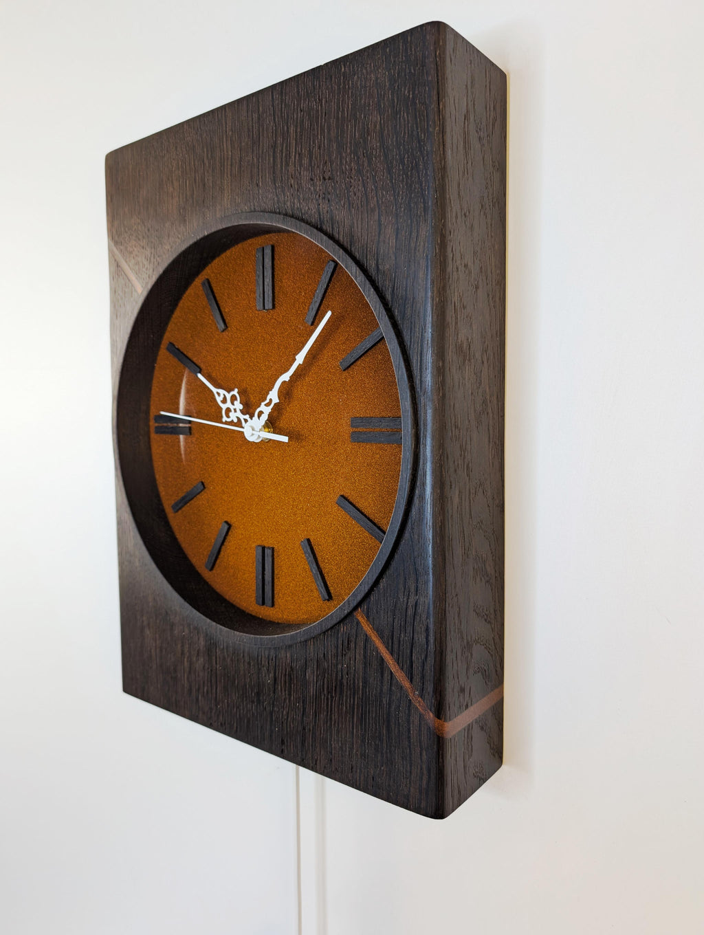 Detailaufnahme der Holzstruktur der Kupferzeit Wanduhr – geräucherte Eiche mit natürlicher Maserung und kupferfarbenem Epoxidharz, Steigerwood Design